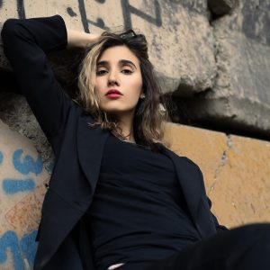 Black Blazer And Pants Sitting Near Concrete Wall